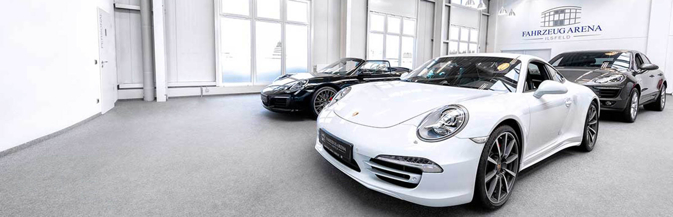 Fahrzeug Arena Ilsfeld GmbH Verschiedene Porsche Modelle in einem Ausstellungsraum